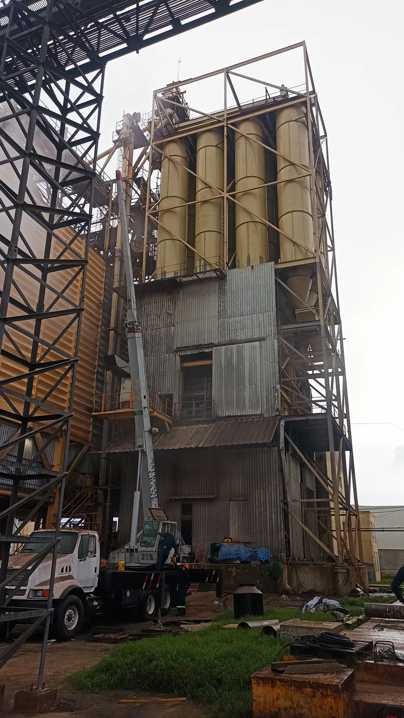 Estructura industrial en construcción al atardecer, con grúa en sitio
